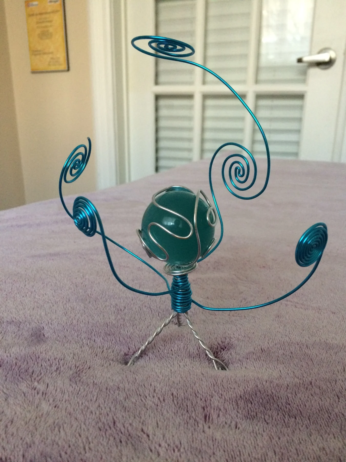 Turquoise wire sculpture with central sphere
