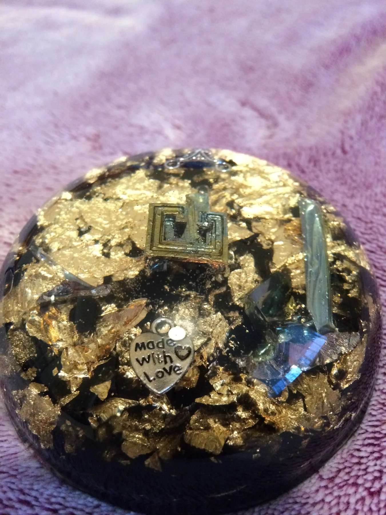 Round resin object with gold leaf and embedded elements