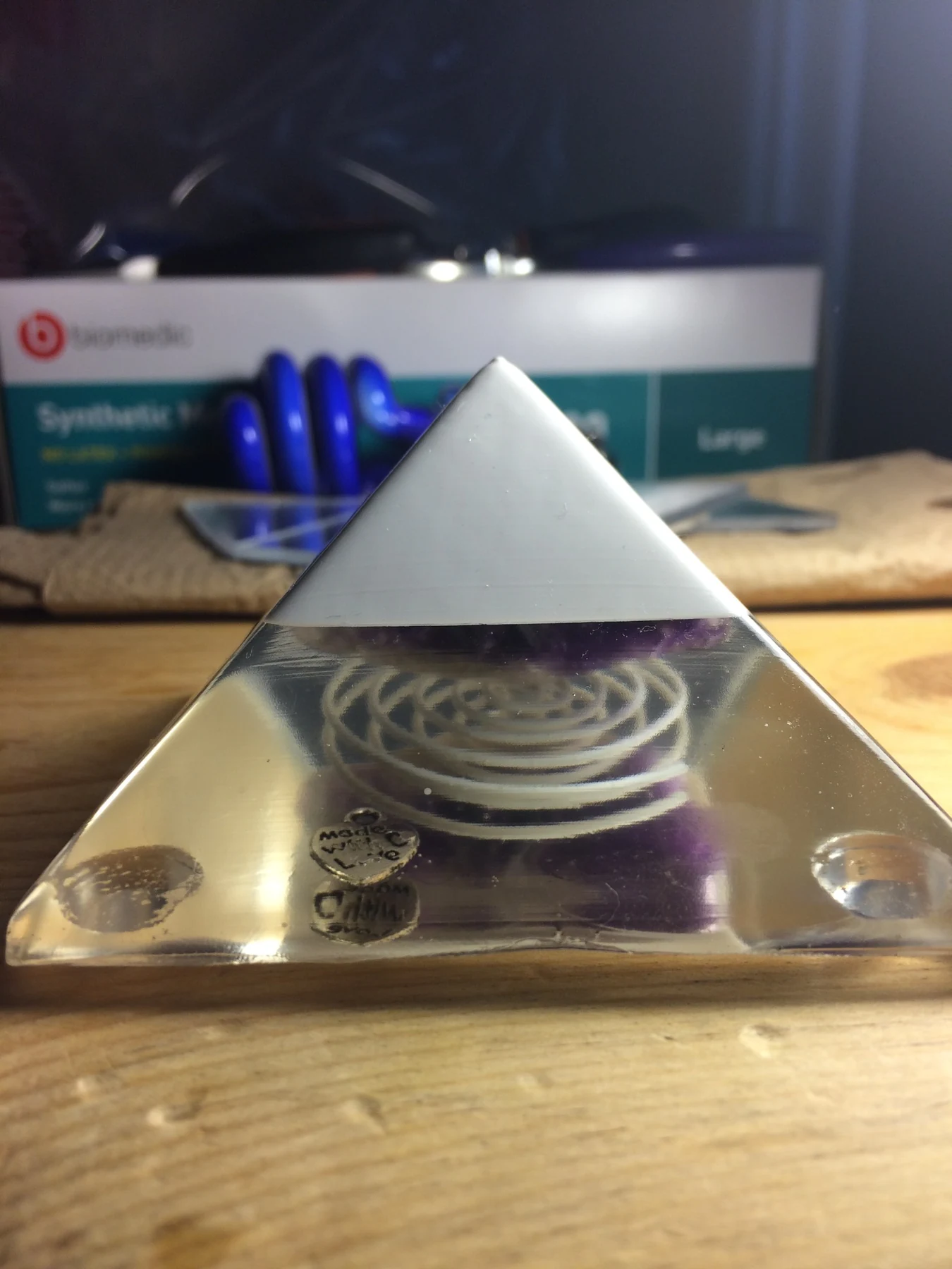 Clear and white resin pyramid with embedded spiral and charms