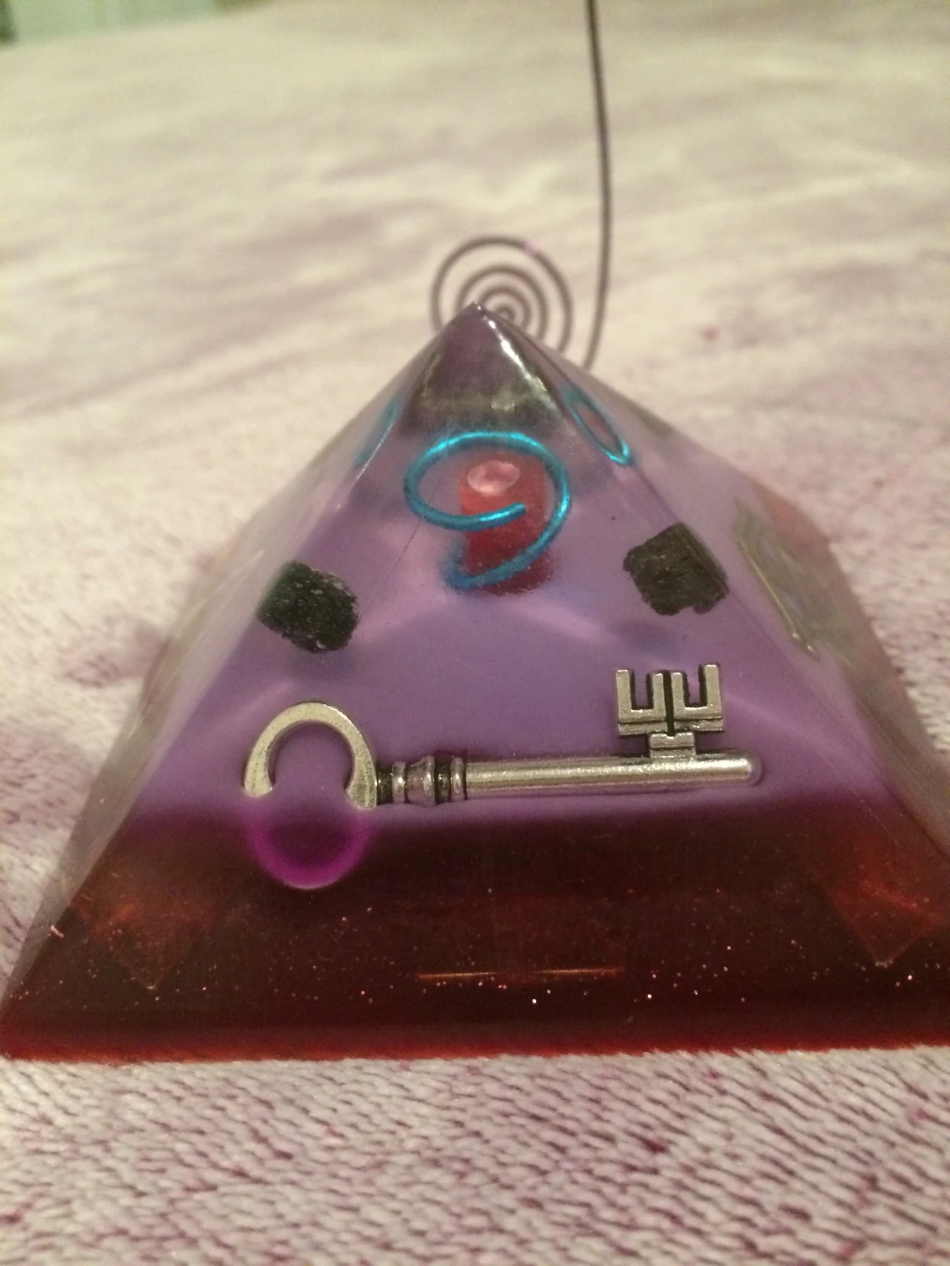 Purple and red resin pyramid with embedded key and spiral